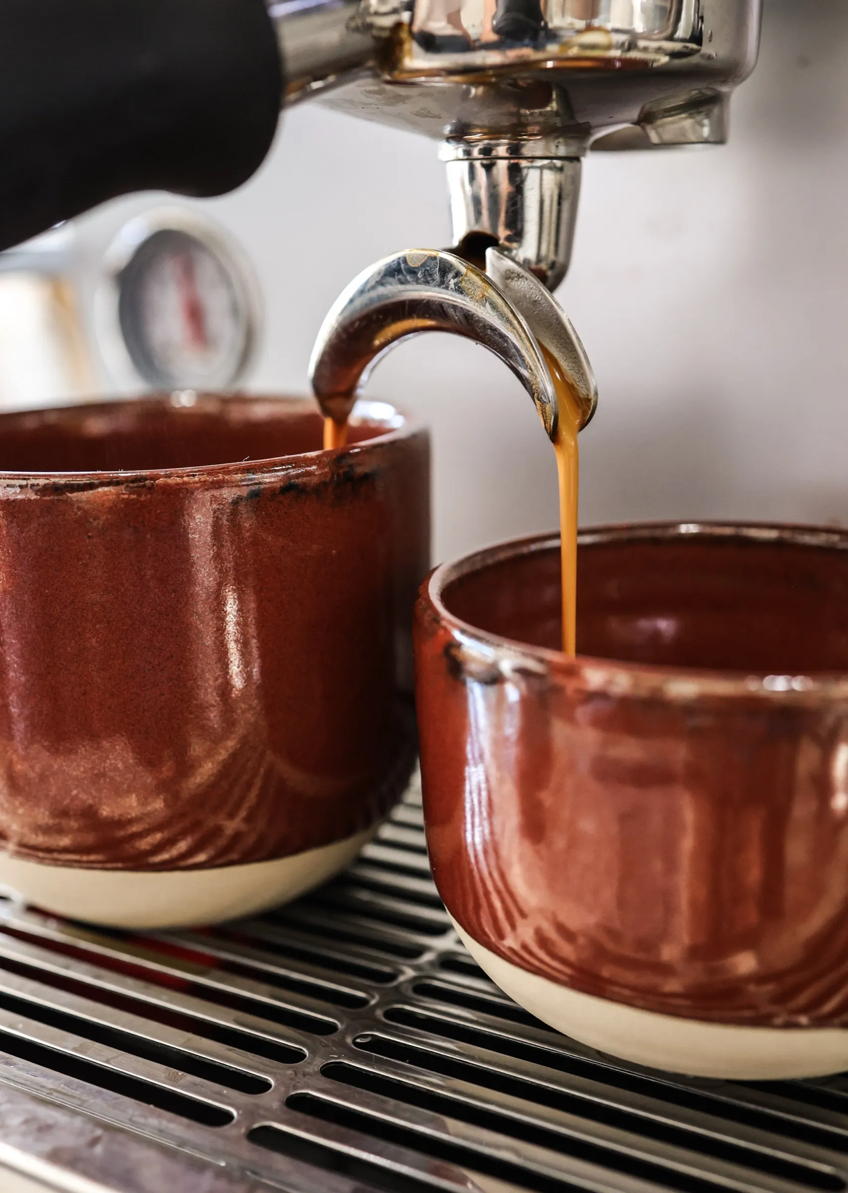 Espresso curgând în două cești de ceramică