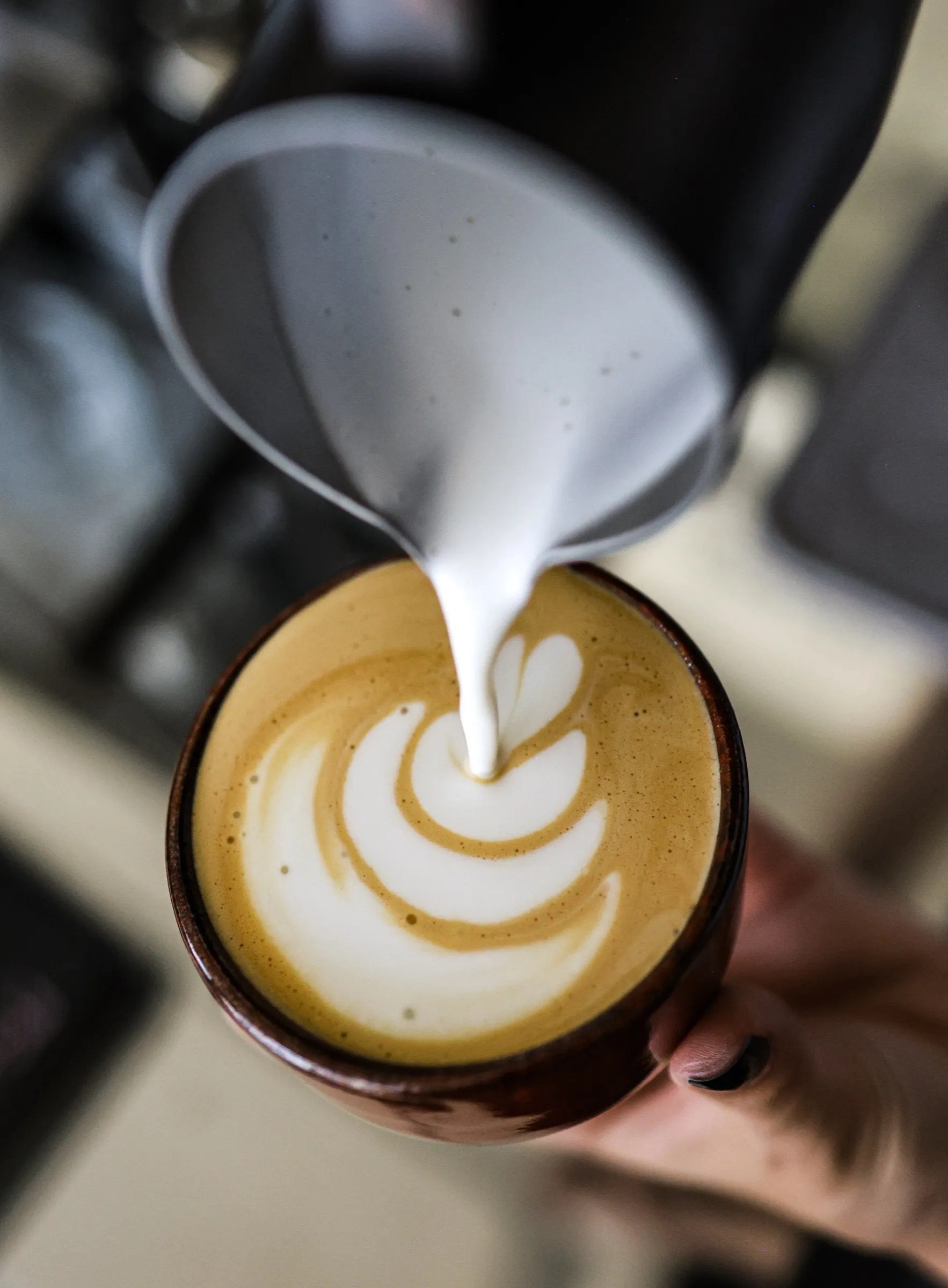 Lapte turnat într-un cappuccino, desen în formă de inimă
